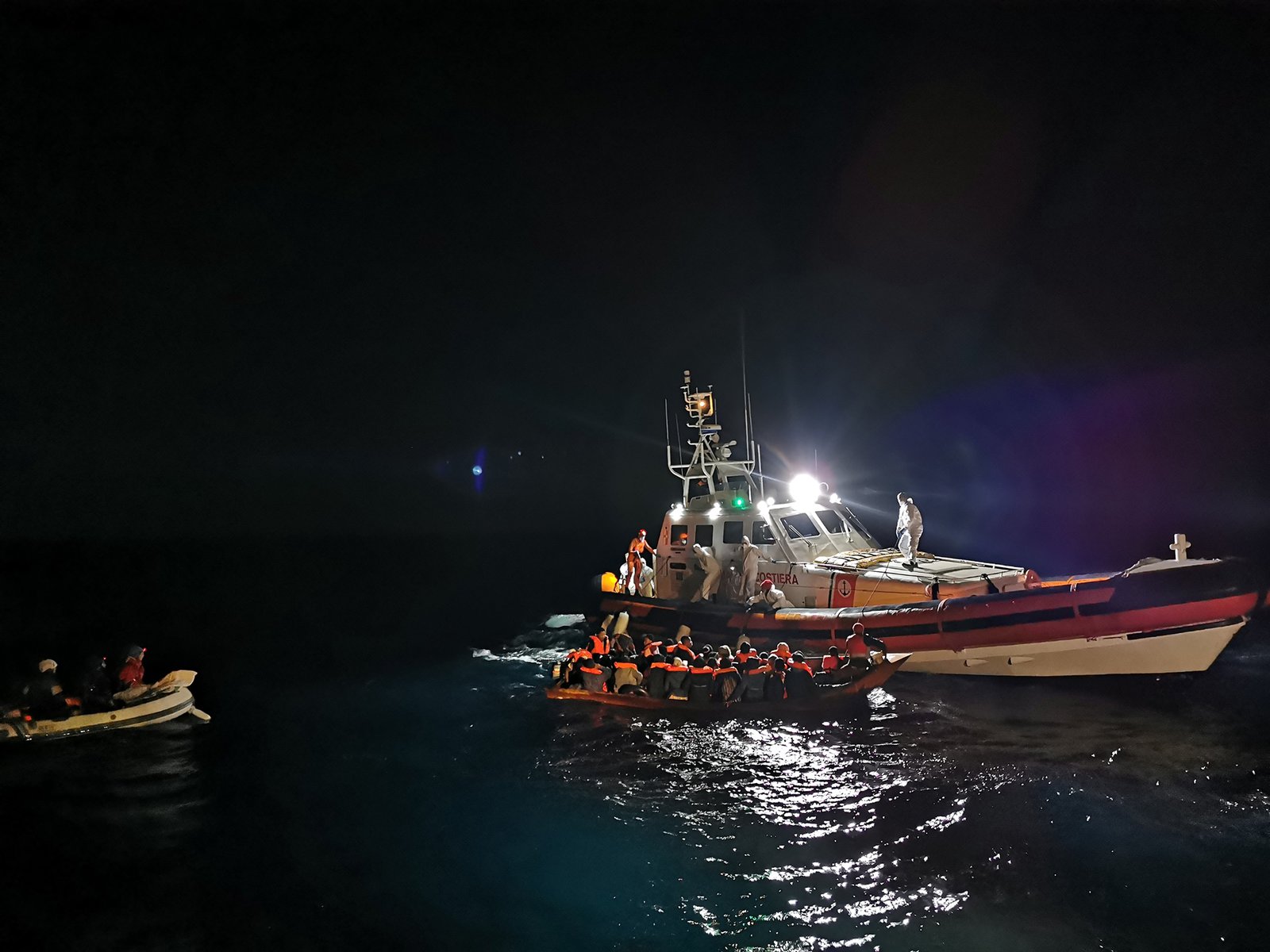 Übergabe-Menschen-in-Boot-an-Küstenwache-nachts