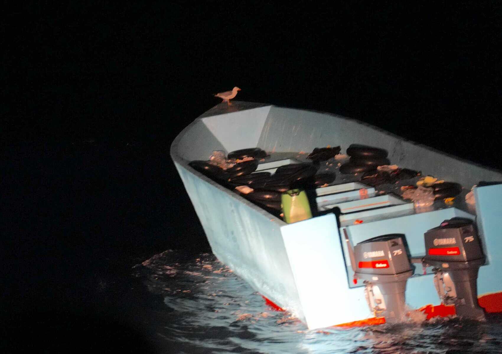 Ein leeres Holzboot, in dem sich neben etlichen Luftkammern, einige Kanister und schwer identifizierbare persönliche Gegenstände befinden