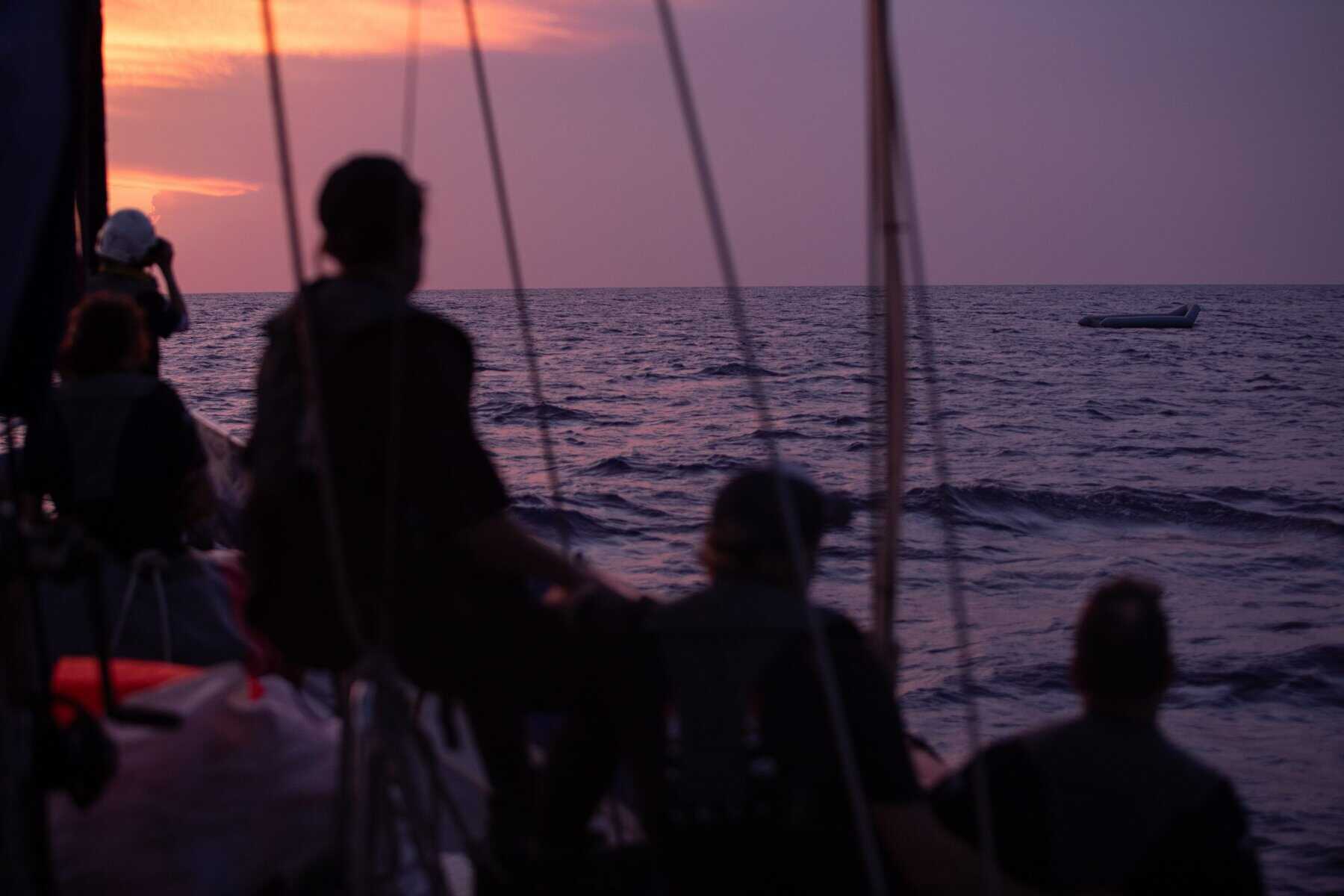 Crewmember und zwei Personen mit Rettungswesten an Bord 