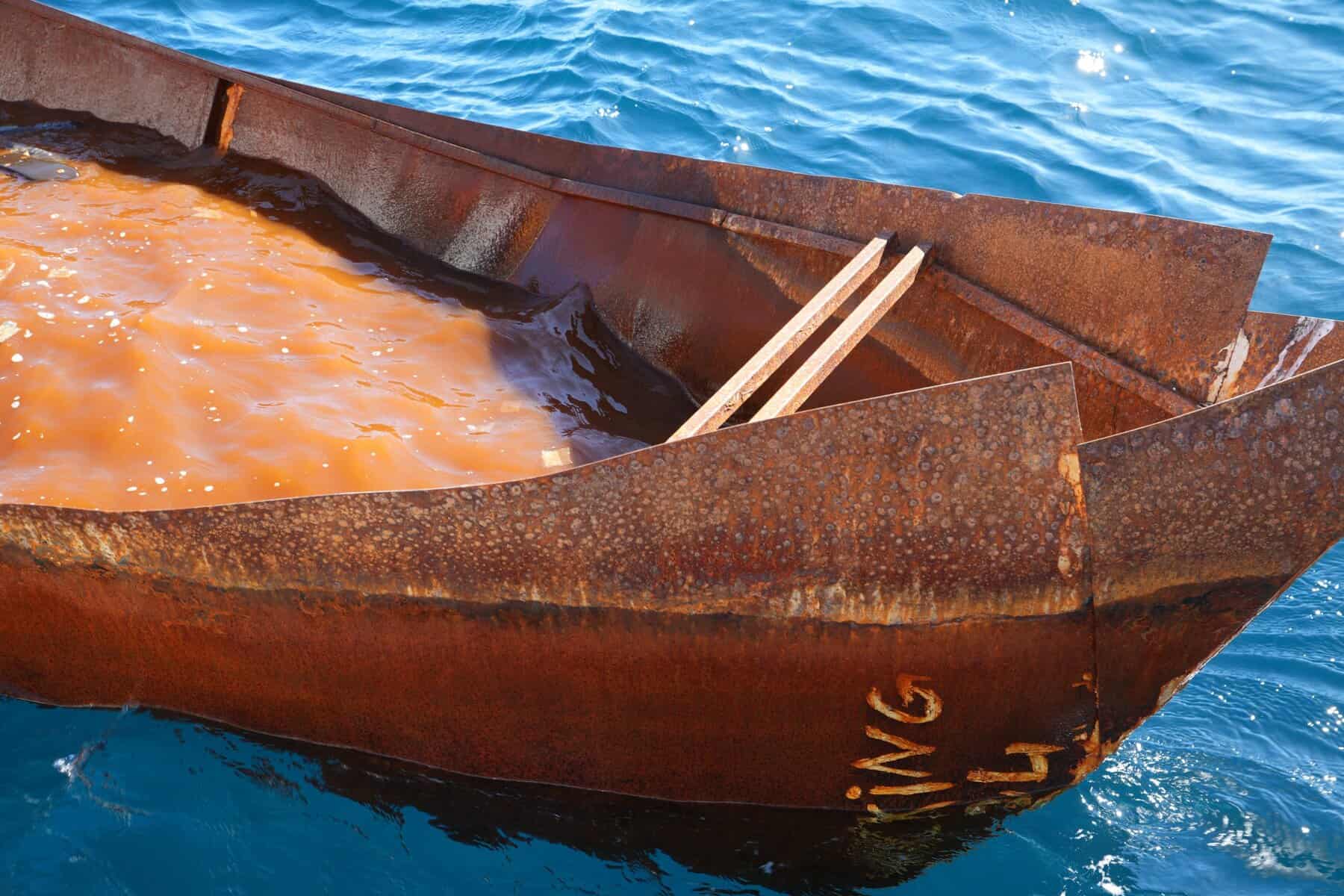 Beiboot vor großem, leeren blauen Holzboot