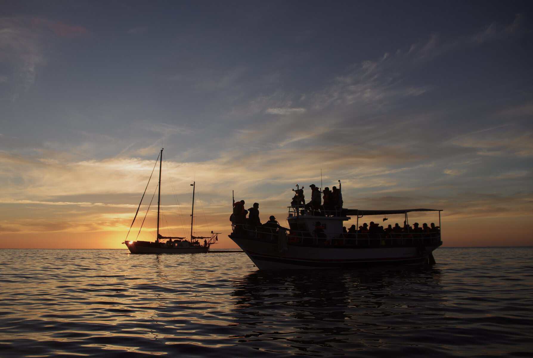 2026_03_NL.03_RESQSHIP_PaulaGaess_OP2022_01 Sonnenuntergang ein Boot im Vordergrund und NADIR im Hintergrund