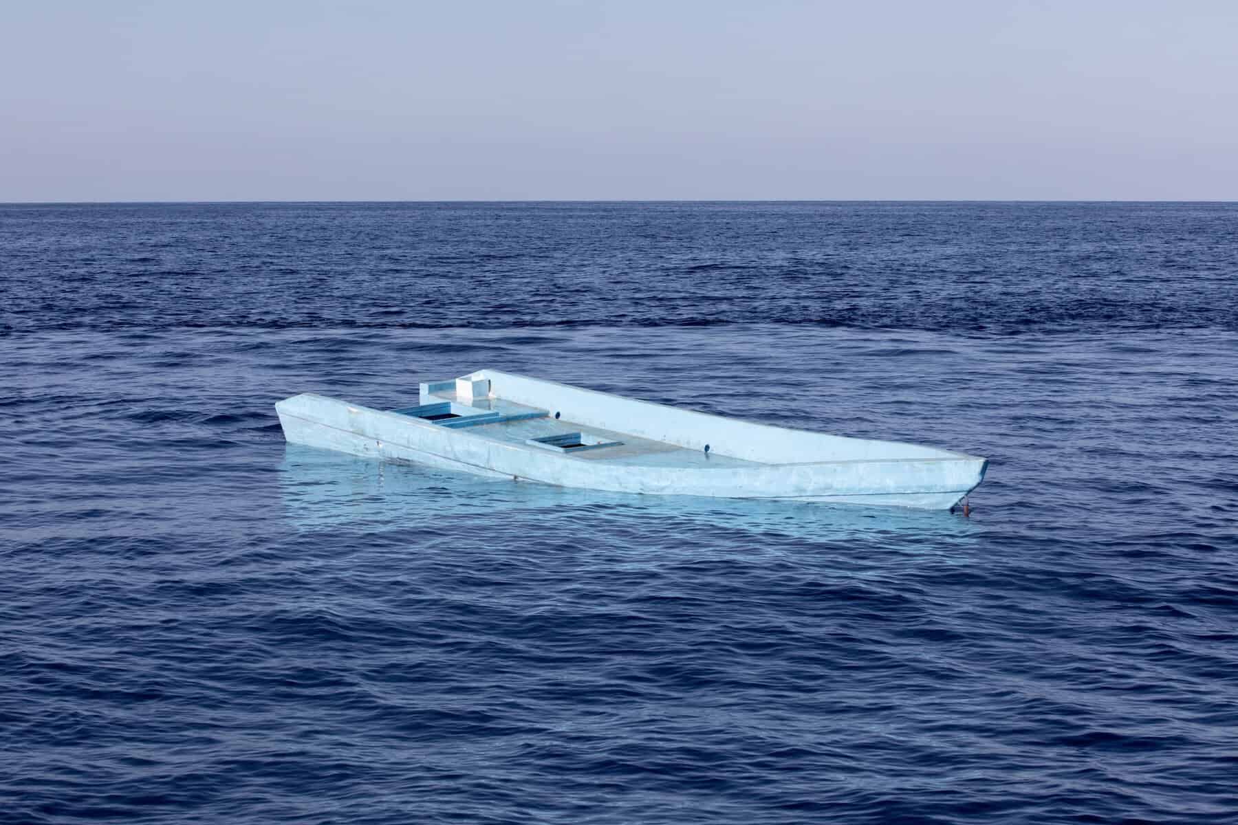 Treibendes Holzboot auf dem Meer