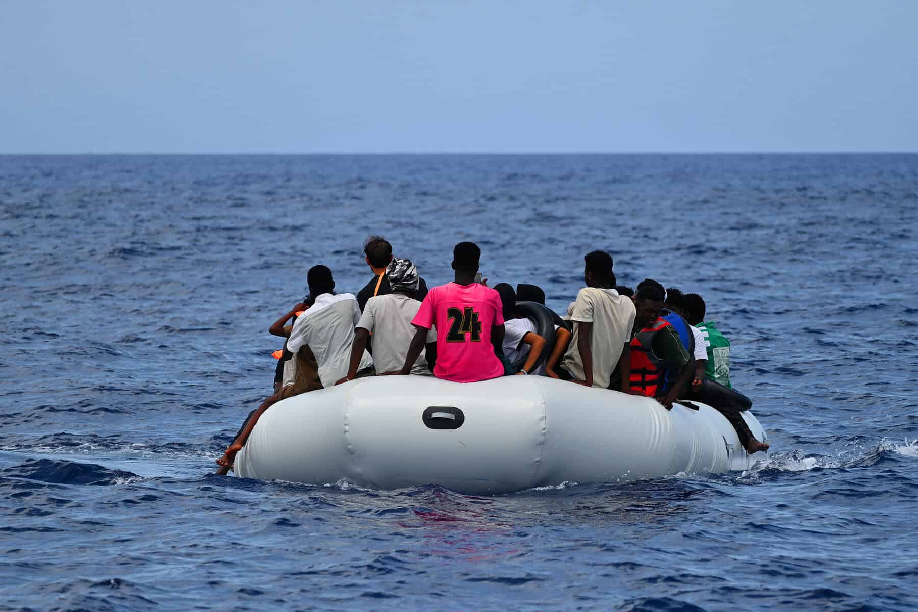 Menschen auf überfüllten Schlauchboot im Meer